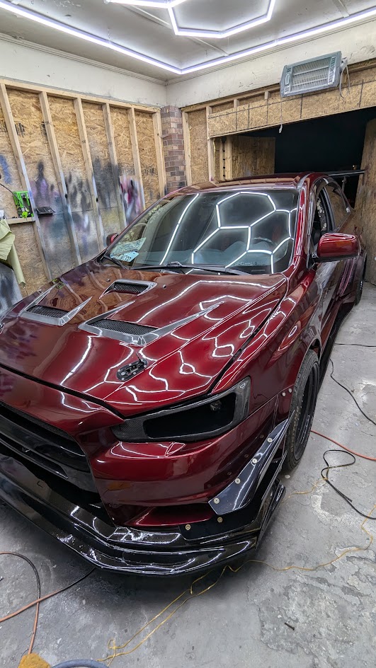 Hood and bodywork reflections under the shop lights